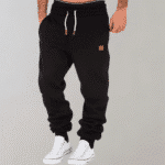 Zwarte joggingbroek voor heren met witte sneakers, koordsluiting en bruin label. Comfortabele sportkleding, ideaal voor casual en sportieve looks.