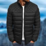 Zwarte gewatteerde herenjas, waterdicht, met ruitpatroon op de schouders. Ideaal voor wintermode en outdooractiviteiten.