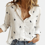 Wit dameshemd met lange mouwen, vogelprint, casual stijl, open kraag, gedragen met blauwe jeans. Perfect voor modieuze dameskleding.