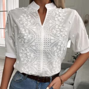 Witte blouse met bloemenborduursel, korte mouwen en opstaande kraag, gedragen door model. Modieuze dameskleding, casual en elegant design.
