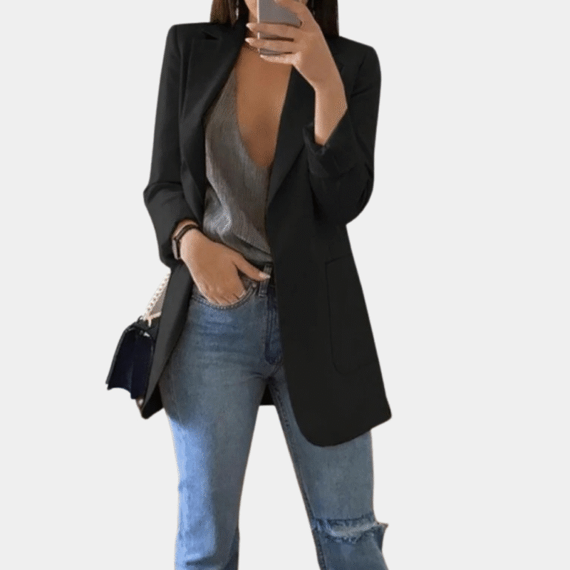 Vrouw in zwarte damesblazer, casual stijl, gecombineerd met grijze top en gescheurde jeans. Perfecte outfit voor moderne, stijlvolle vrouwen.
