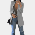 Grijze damesblazer, casual stijl, gecombineerd met een grijze top en blauwe jeans. Perfect voor modieuze, dagelijkse outfits.