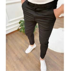 Zwarte slim-fit broek voor heren, gedragen met witte sneakers. Stijlvolle casual outfit, ideaal voor moderne mode en comfort.