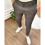 Donkergrijze slim-fit broek voor heren, gedragen met witte sneakers. Stijlvolle en moderne herenmode, ideaal voor casual en zakelijke gelegenheden.
