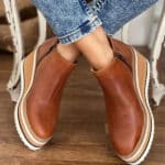 Bruine damesenkelboots met ritssluiting, dikke witte zool en casual design. Perfect voor herfstmode en comfortabele dagelijkse stijl.