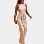 Vrouw in elegante gouden glitter jumpsuit met ceintuur, perfect voor feestelijke gelegenheden. Trendy damesmode, avondkleding, stijlvolle outfit.