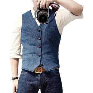 Man in blauw gilet met knopen, witte overhemd en jeans, houdt camera vast. Stijlvolle herenkleding, casual mode, fotografie-accessoire.