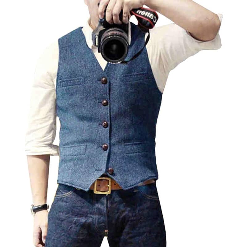Man in blauw gilet met knopen, witte overhemd en jeans, houdt camera vast. Stijlvolle herenkleding, casual mode, fotografie-accessoire.