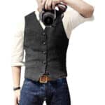 Man in grijs gilet en witte overhemd, houdt camera vast. Stijlvolle herenkleding, casual mode, gilet met knopen, fotografie-accessoire.