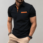 Zwarte herenpolo met oranje accenten, korte mouwen en kraag. Stijlvolle casual outfit, perfect voor modebewuste mannen.