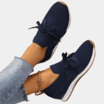 Stijlvolle donkerblauwe damessneakers met strikdetail, comfortabele pasvorm en witte zool, perfect voor casual en sportieve outfits.