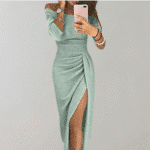 Vrouw in elegante, mintgroene glitterjurk met split en off-shoulder design. Perfect voor feestelijke gelegenheden. Trendy damesmode, avondjurk.